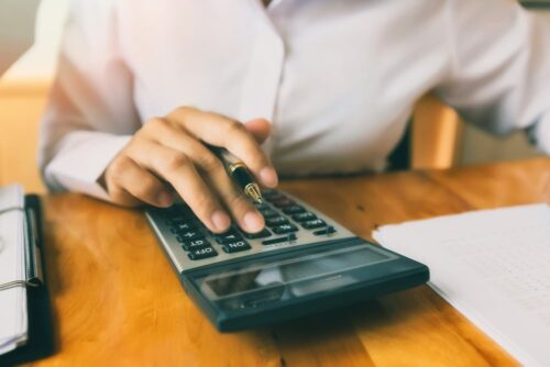 man typing on a calculator