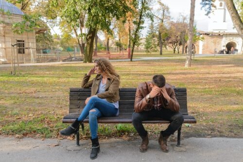 upset couple on park bench