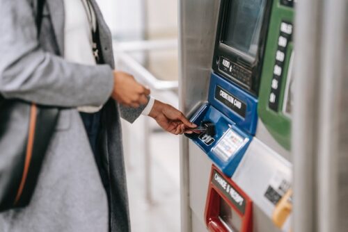 person taking money out of atm