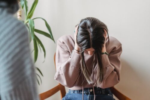 woman holding head in her hands