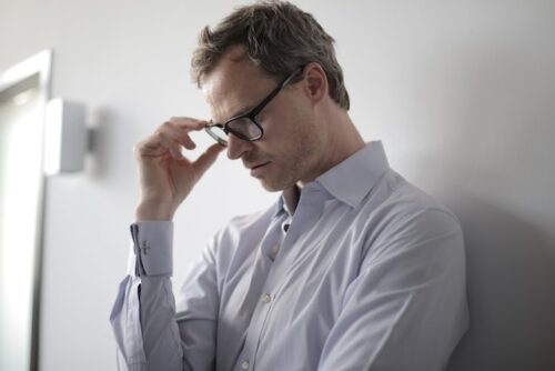 man in glasses looking distressed