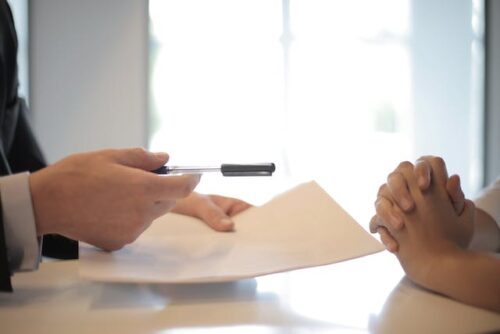 person holding pen and paper