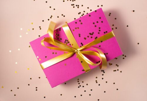 pink gift with gold confetti and ribbon