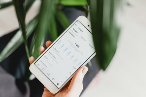 person holding phone with analytics on screen