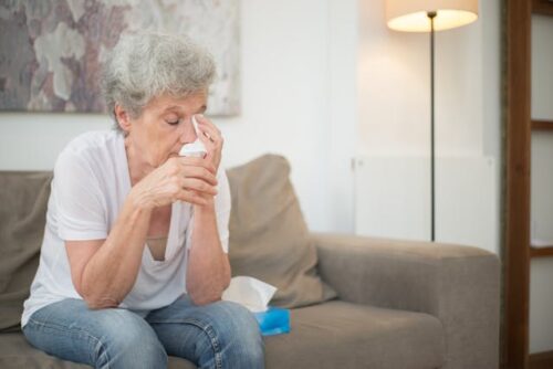 older woman holding tissue crying